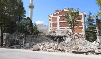 Yıkılan binanın molozları cami bahçesine döküldü